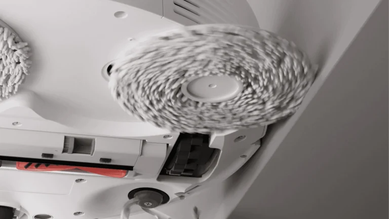 Vedere de dedesubt a robotului Roborock Qrevo 5AE, cu mopul rotativ din dreapta extins spre perete